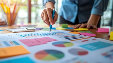 Fototapeta premium Businesswoman analyzing data charts with sticky notes