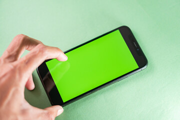 Hand Interacting with Smart phone on Green Background