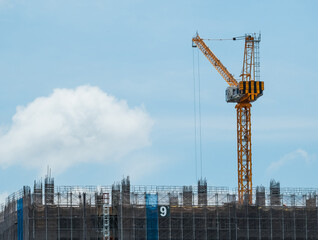 Building under construction, cranes and high-rise building