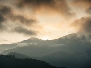a mountain range with a sunset in the background.