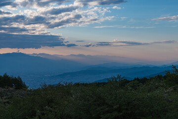 日本　長野県岡谷市と塩尻市の境にある高ボッチ山の高ボッチ高原から見える山のグラデーションと夕焼け空