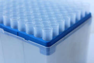a set of plastic pipette tips in a stand. A blue tip for scientific experiments in a box....
