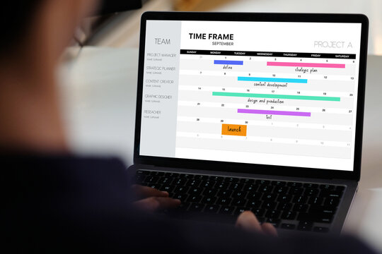 Laptop computer with timeline project schedule, work plan mangement, on screen at office background