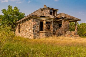 An abandoned stone house covered with vines on the Saskatchewan prairies in Canada