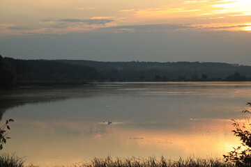 Beautiful landscape of the sunrise at a foggy river in the morning