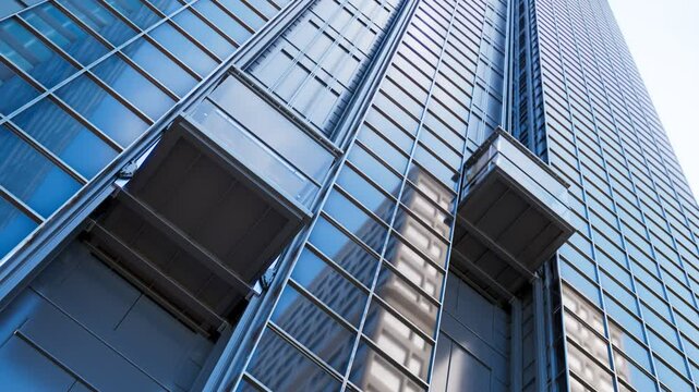 Exterior Elevator Cabins Traveling Upwards On A Skyscraper Glass Facade Three Exterior Elevator Cabins Travelling Upwards On A Skyscraper Glass Facade Other Downtown Buildings Reflected