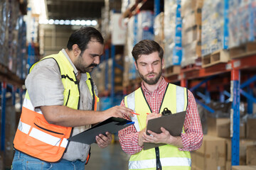 Warehouse concept. Two male warehouse worker working and checking boxes of products on shelf in warehouse. Group of two male worker at warehouse