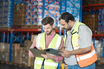 Warehouse concept. Two male warehouse worker working and checking boxes of products on shelf in warehouse. Group of two male worker at warehouse