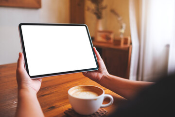 Mockup image of a woman holding digital tablet with blank desktop screen at home