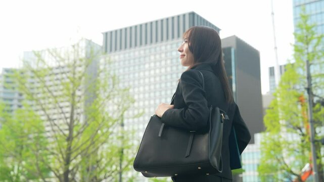 爽やかに街を歩く女性ビジネスパーソンのサークルショット