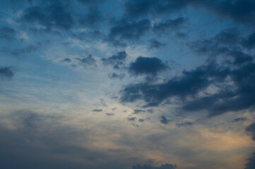 dark blue clouds in the lower layers of the atmosphere; whiter clouds in white layers; some of the clouds are colored by the rays of the sun in pale orange shades
