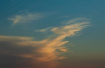 Cumulus mediocris cloud partly spreading into stratocumulus cumulogenitus  colored by the sun in yellow dark orange and dark pink shades