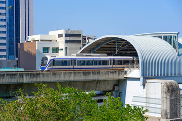 Modern train metro viaduct moving on rails above the ground in the city skyscrapers. Subway cars...