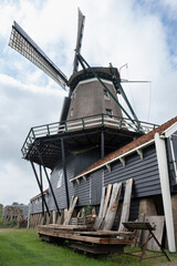 Historic saw mill 'The Rat' and barn in IJlst, Friesland, the Netherlands. Sawn planks lie and stand next to the mill © Henk Vrieselaar