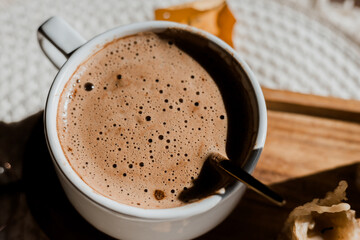 Mocha coffee in a white flatlay cup, autumn coffee, morning routine, coffee in the sunlight, wax candles, cozy breakfast, coffee with foam, mocha on a wooden table and a round napkin, autumn leaves