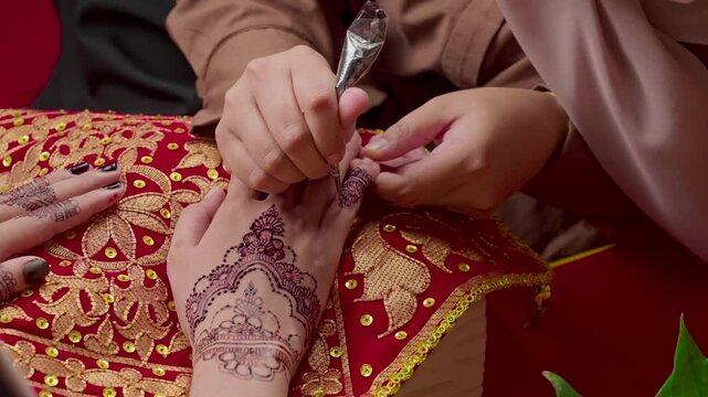 The process of painting henna on the bride's hands. There are many different names for henna tattoo across the globe, such as mehndi, inai, hina, camphire, and hena