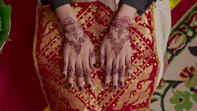 The bride's hands decorated with henna. There are many different names for henna tattoos around the world, such as mehndi, inai, hina, camphire, and hena
