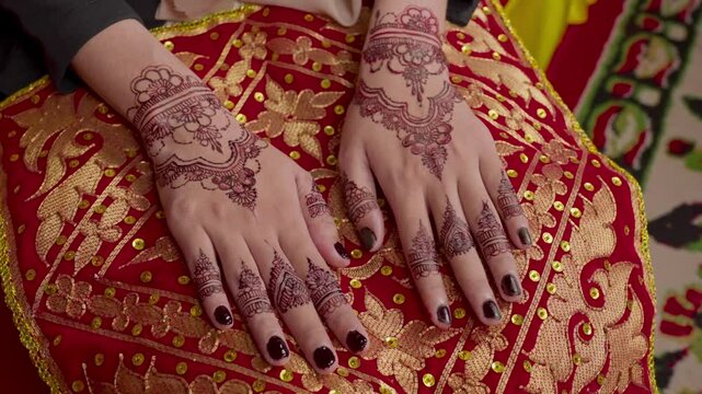 The process of painting henna on the bride's hands. There are many different names for henna tattoo across the globe, such as mehndi, inai, hina, camphire, and hena