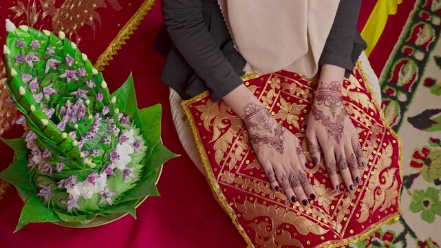 The bride's hands decorated with henna. There are many different names for henna tattoos around the world, such as mehndi, inai, hina, camphire, and hena