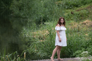 Naklejka premium Beautiful young dark-haired girl by the river.
