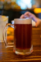 Glass of beer on the table with blur background