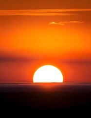 An icon of the sun partially rising over a horizon, symbolizing morning or dawn
