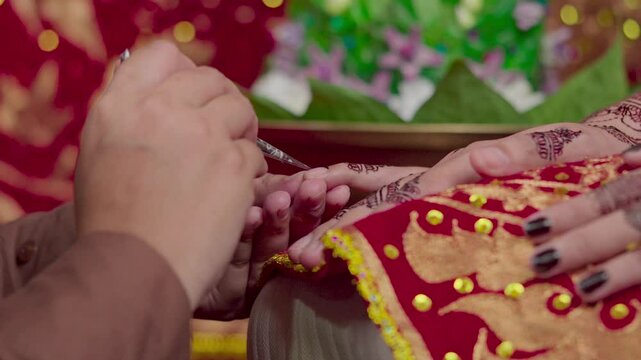 The process of painting henna on the bride's hands. There are many different names for henna tattoo across the globe, such as mehndi, inai, hina, camphire, and hena