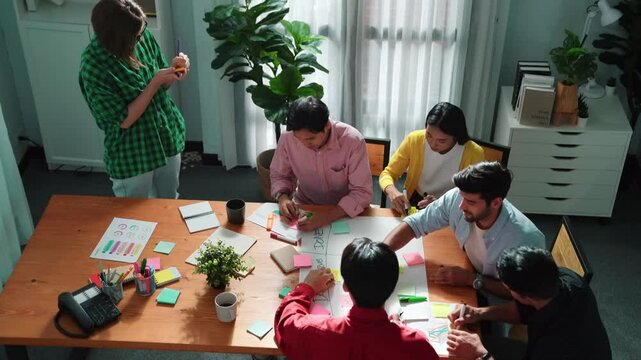 Top view of business people hands making scrum task board to manage workflow in workplace. Diverse marketing team writing sticky notes while working on kanban. Creative startup project. Directorate.