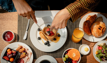 Breakfast at a table with a woman's hands.