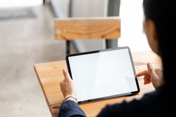 Closeup image of young woman holding digital tablet with blank white desktop screen in cafe