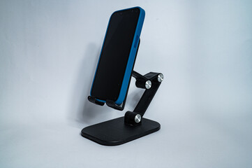 Mobile phone is placed on a table stand. Isolated on a transparent background.