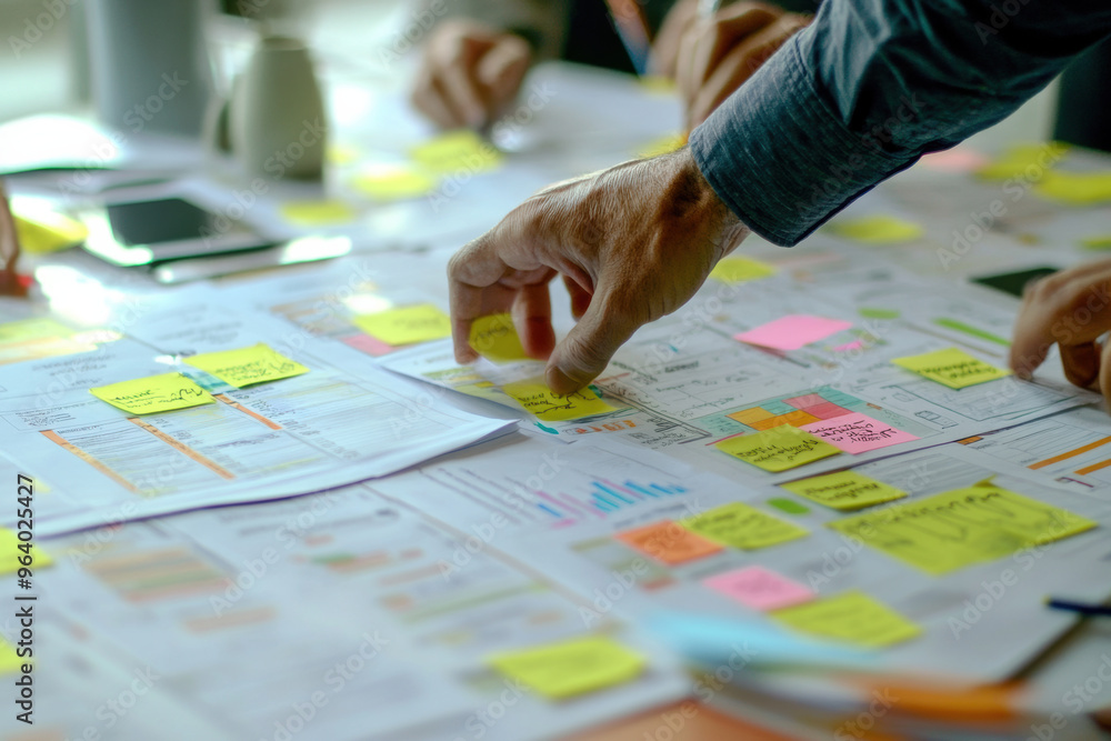 Poster brainstorming session with sticky notes and documents on table, showcasing collaboration and plannin