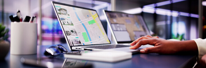 African woman using laptop to search online real estate property listings