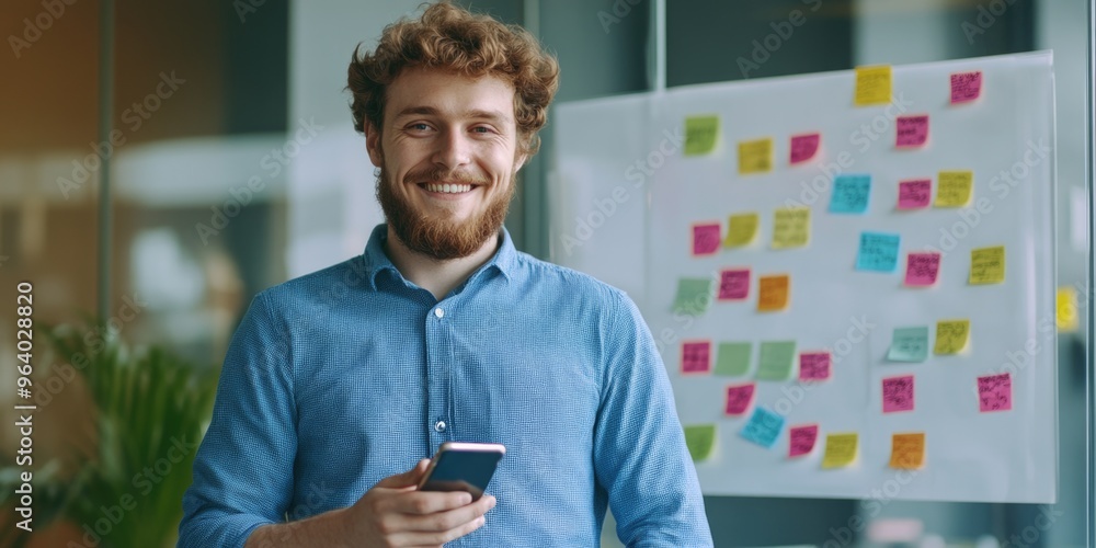 Aufkleber a man with a beard is smiling and holding a cell phone. he is standing in front of a white board wit