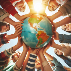 groupe d'enfants souriant, en contre plongée qui tiennent un globe terrestre entre leurs mains, symbolise et illustre le vivre ensemble, la fraternité, le partage et la tolérance 
