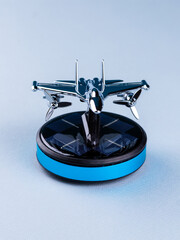 Close-up of metal airplane model on podium on blue background