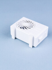 close up of small model of air conditioner on blue background