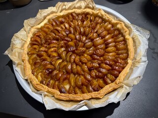 Golden brown baked mirabelle of Lorraine plum tart with a flaky pastry crust, perfectly arranged caramelized mirabelle slices, showcasing rich textures, rustic charm, and seasonal dessert presentation