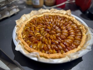Golden brown baked mirabelle of Lorraine plum tart with a flaky pastry crust, perfectly arranged caramelized mirabelle slices, showcasing rich textures, rustic charm, and seasonal dessert presentation