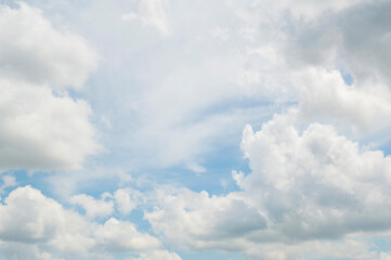 clear blue sky almost completely surrounded by clouds and covered with scattered clouds in the center