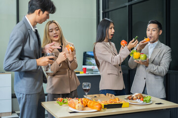 Asian business team are excited business success with inspiration from their excellent financial results, celebration successful deal with champagne and pizza in the workplace.