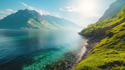Obraz premium Breathtaking mountain view with clear sea water and lush green grass under a bright sky, capturing the beauty of nature in daylight