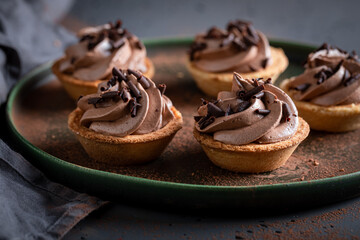 Sweet mini tartlets with sprinkles and chocolate cream.