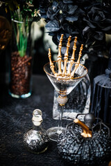 Halloween Party. Luxury Golden skeleton hand in a champaign glass surrounding with potion bottle, pumpkin and spider decorated for Luxury Halloween Party