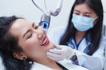 Side view of asian woman getting resurfacing laser fraxel dual and ultrasound face treatment in...