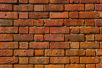 Close-up of a weathered brick wall, showcasing a variety of warm tones and textures.