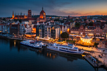 Obraz premium Gdansk, Poland - July 18, 2024: The Main Town of Gdansk by the Motlawa river at dusk, Poland.