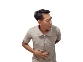 Fototapeta premium young asian man posing on a white backdrop wearing gray polo t shirt hands holding stomach, having a liver pain, stomach ache.