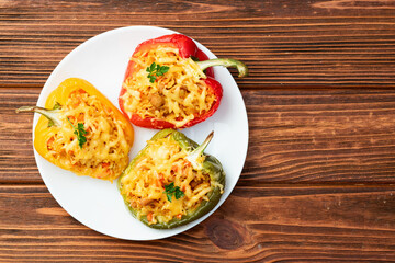 Baked stuffed pepper ( paprika ) with rice , carrot and meat . Top view on rustic background
