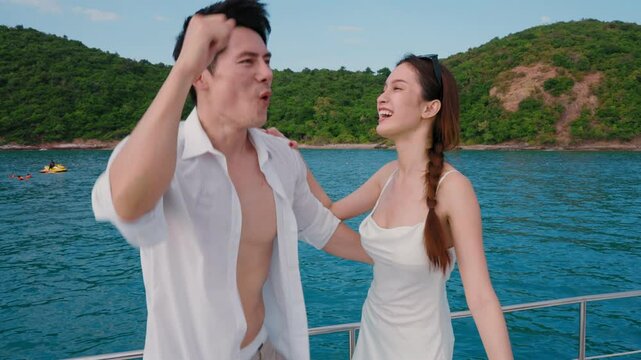 Asian couple enjoys a happy honeymoon trip on a yacht.